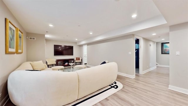 living area with visible vents, light wood-style flooring, baseboards, and recessed lighting