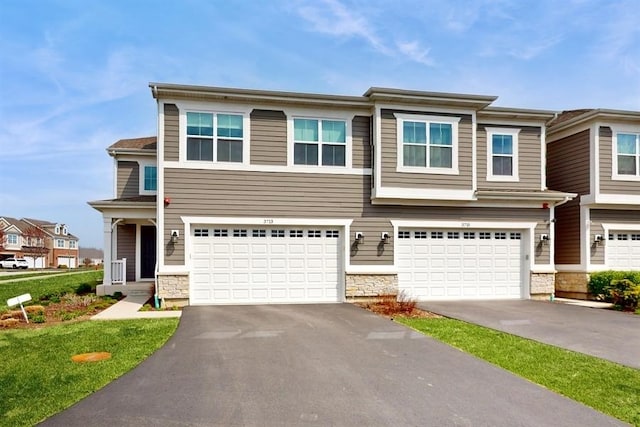 view of front of home with a garage, stone siding, and driveway
