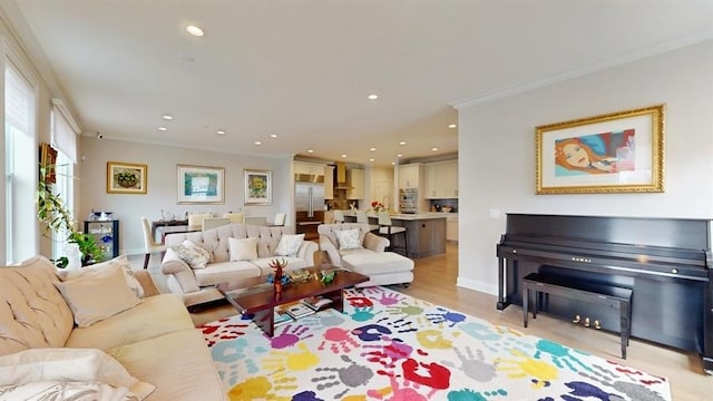 living area featuring light wood-style flooring, baseboards, ornamental molding, and recessed lighting