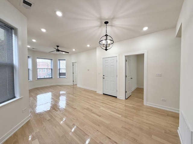 unfurnished room featuring visible vents, light wood finished floors, recessed lighting, and ceiling fan with notable chandelier