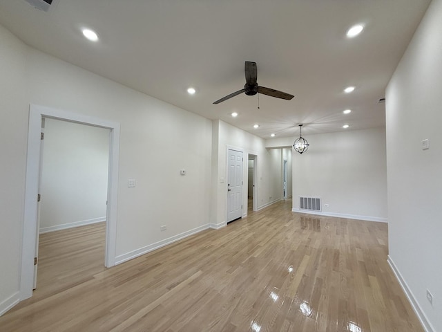 empty room with baseboards, recessed lighting, a ceiling fan, visible vents, and light wood finished floors