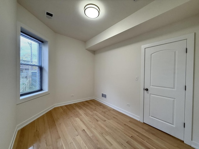 spare room featuring visible vents, baseboards, and light wood-type flooring