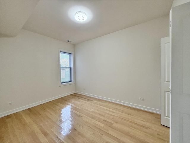 spare room featuring light wood finished floors and baseboards