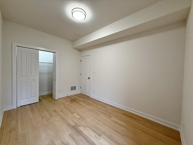 unfurnished bedroom with visible vents, baseboards, a closet, and light wood-style floors