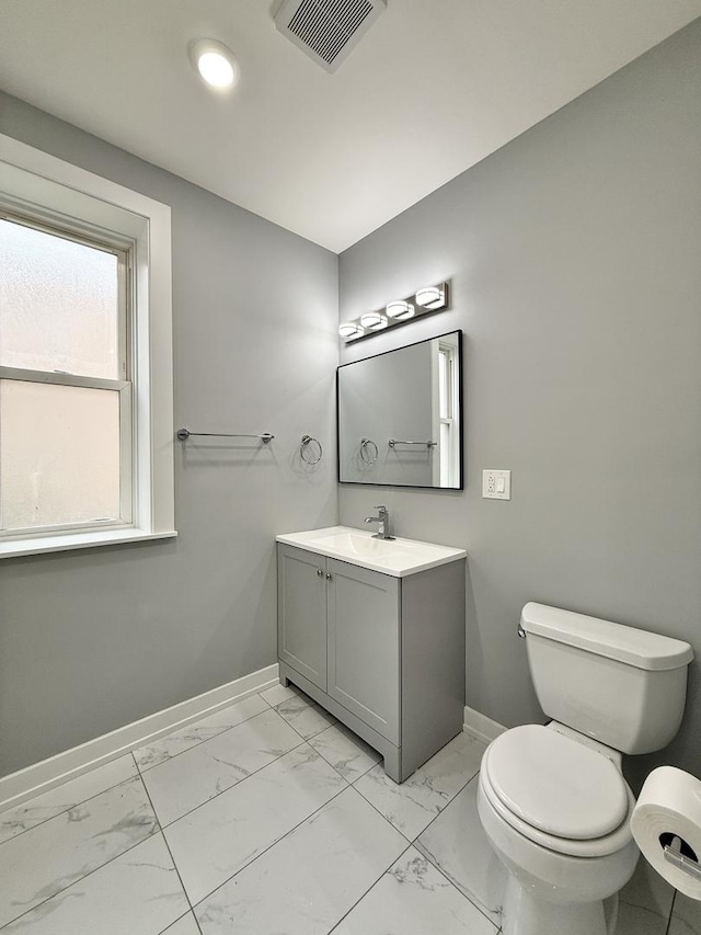 half bath featuring visible vents, baseboards, toilet, vanity, and marble finish floor