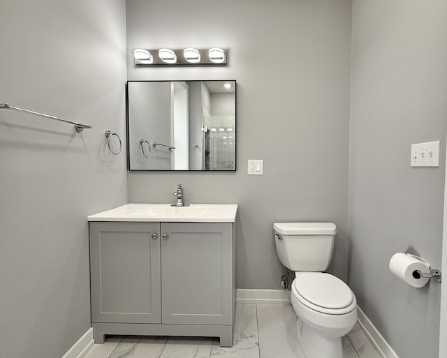 full bath featuring toilet, marble finish floor, baseboards, and vanity