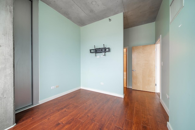 spare room featuring baseboards and wood finished floors