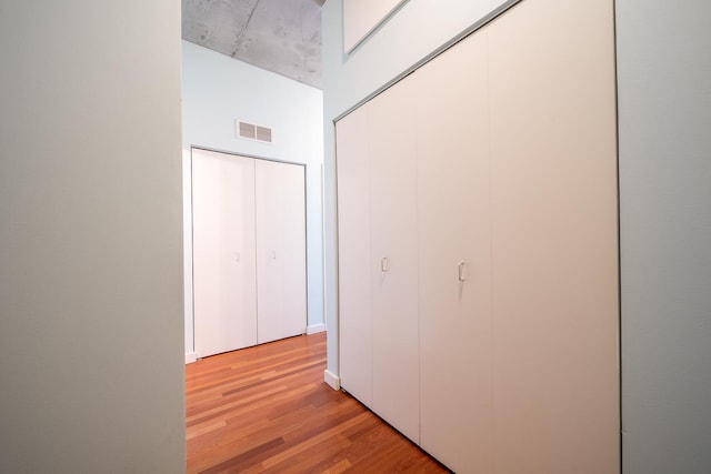 corridor featuring light wood finished floors and visible vents