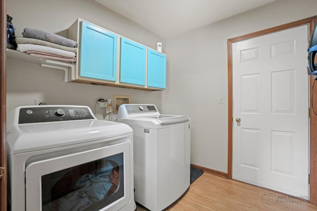 laundry room featuring light wood-style flooring, baseboards, washer and clothes dryer, and cabinet space
