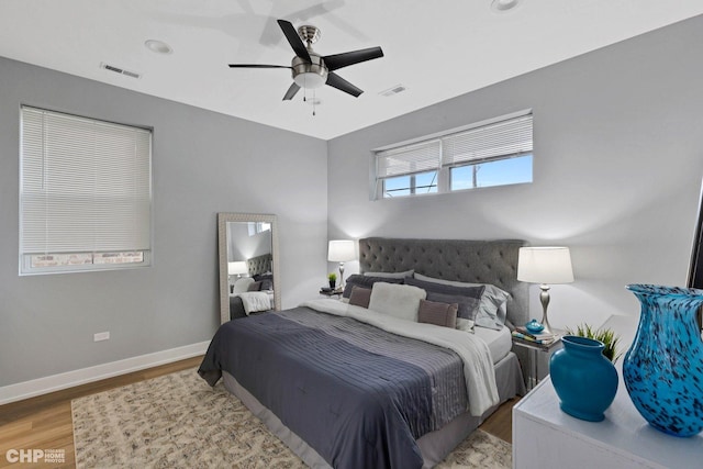bedroom with visible vents, baseboards, a ceiling fan, and wood finished floors