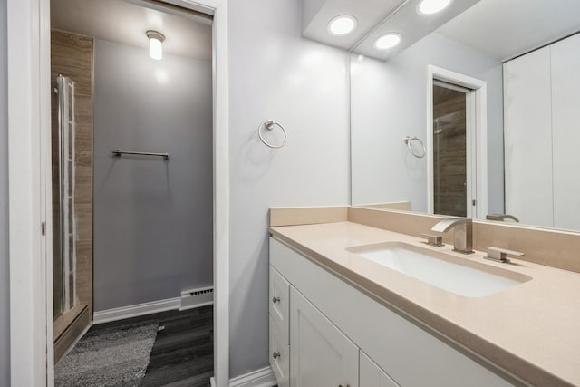 full bathroom with vanity, recessed lighting, baseboards, and a tile shower