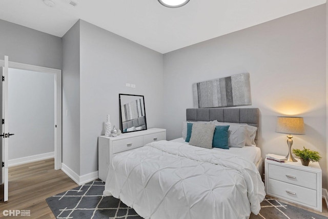 bedroom featuring dark wood-style flooring and baseboards
