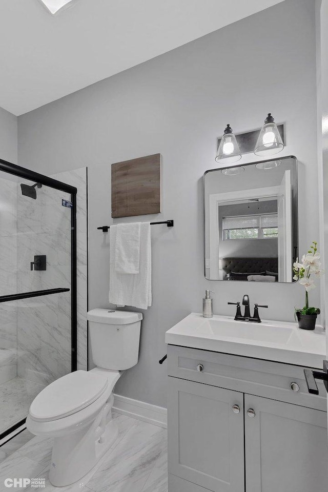 bathroom featuring a shower stall, vanity, toilet, marble finish floor, and baseboards