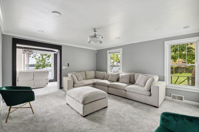 135 Cora Ave, Fox Lake, IL 60020 - living area with carpet, crown molding, a chandelier, and baseboards