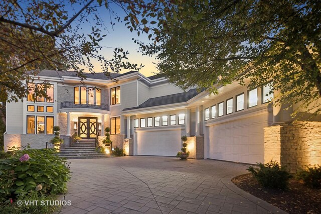 1525 Woodcrest Ct, Aurora, IL 60502 - contemporary home with stone siding, a chimney, a garage, a balcony, and decorative driveway