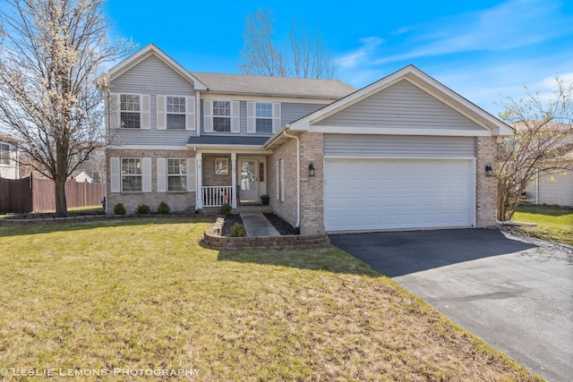 traditional home featuring aphalt driveway, an attached garage, fence, a front yard, and brick siding