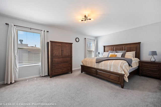 bedroom with light carpet, visible vents, and baseboards
