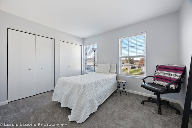 bedroom featuring multiple closets, baseboards, and carpet floors