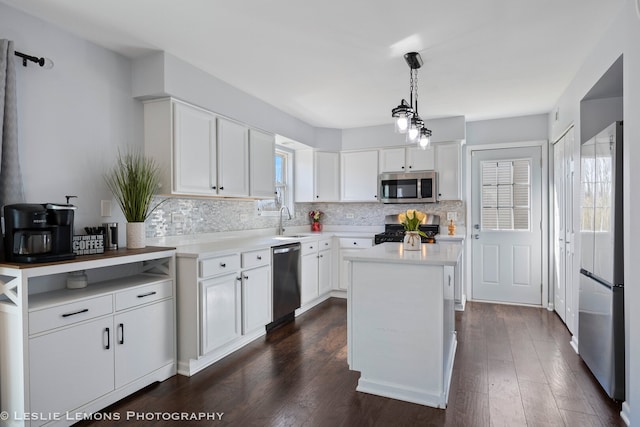 kitchen with stainless steel appliances, a sink, white cabinetry, decorative backsplash, and light countertops