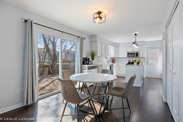 dining room with baseboards and dark wood-type flooring