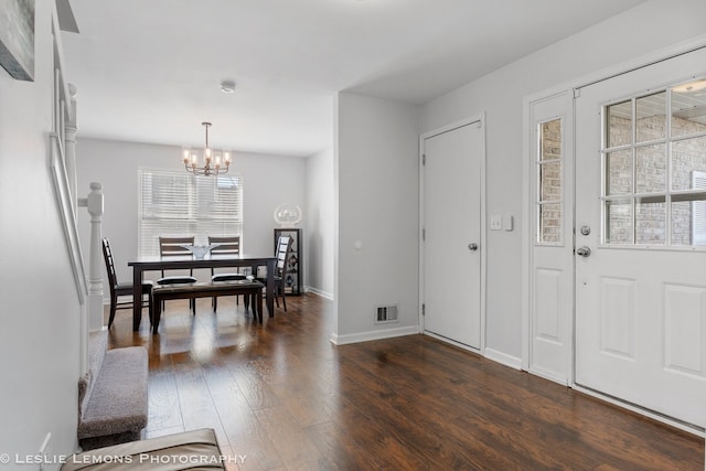 entrance foyer with baseboards, visible vents, an inviting chandelier, and dark wood-style floors