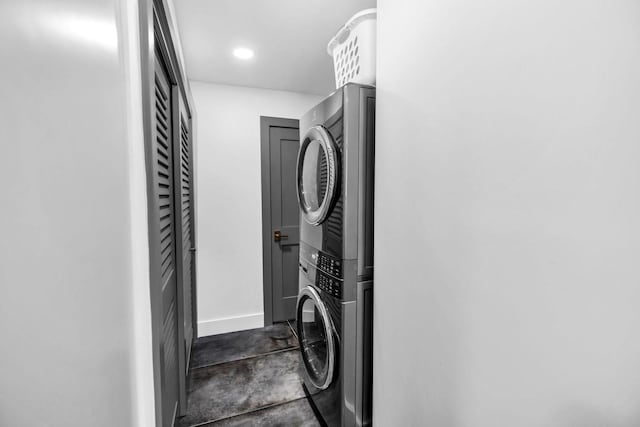 laundry area featuring stacked washing maching and dryer, laundry area, and baseboards