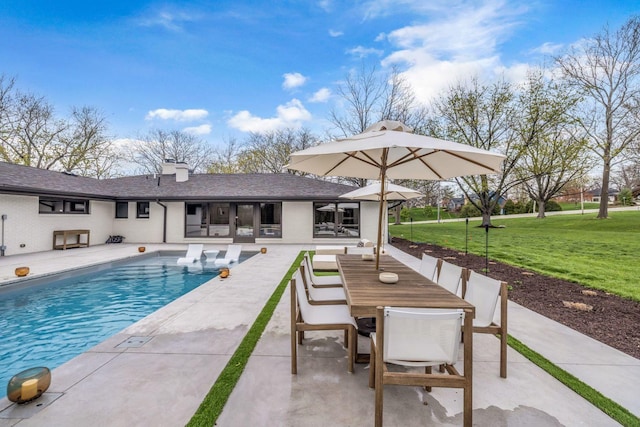 outdoor pool featuring a patio, outdoor dining space, and a lawn