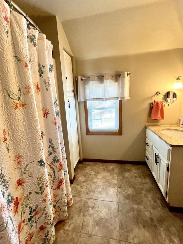 full bathroom with baseboards, vaulted ceiling, vanity, and curtained shower