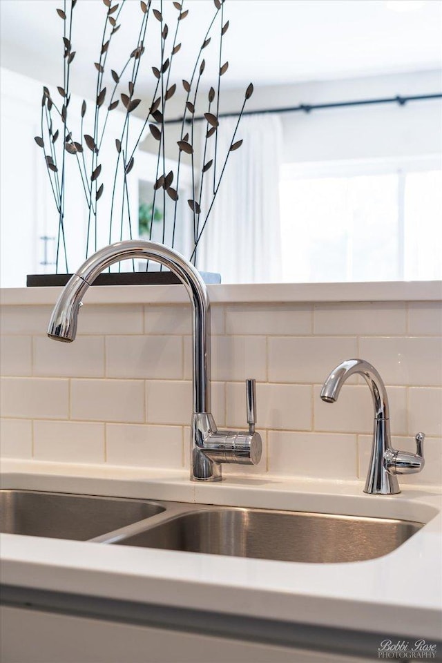 details featuring decorative backsplash, light countertops, and a sink