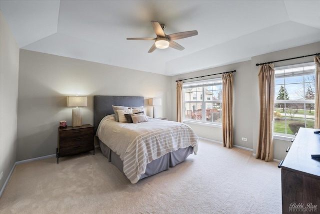bedroom featuring light carpet, a ceiling fan, vaulted ceiling, and baseboards