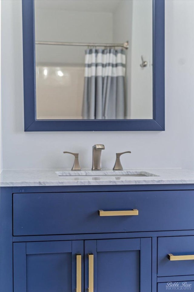 details with vanity and a shower with shower curtain