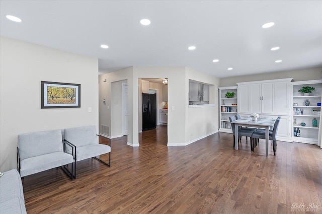 interior space with baseboards, visible vents, dark wood-style floors, and recessed lighting
