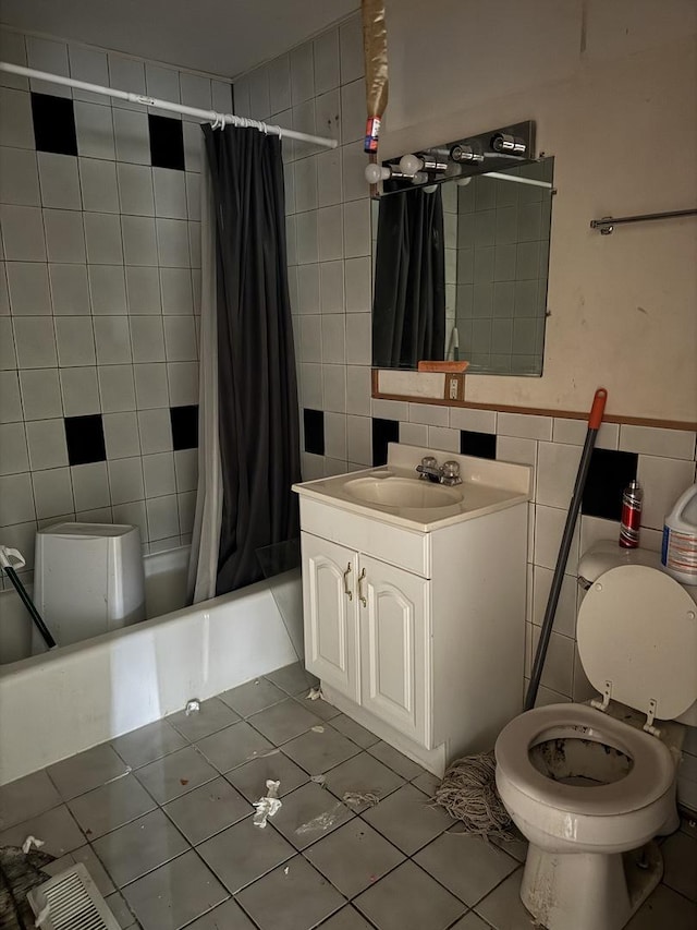 bathroom featuring tile patterned floors, vanity, shower / bathtub combination with curtain, tile walls, and toilet