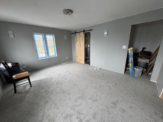 interior space featuring a barn door and carpet flooring