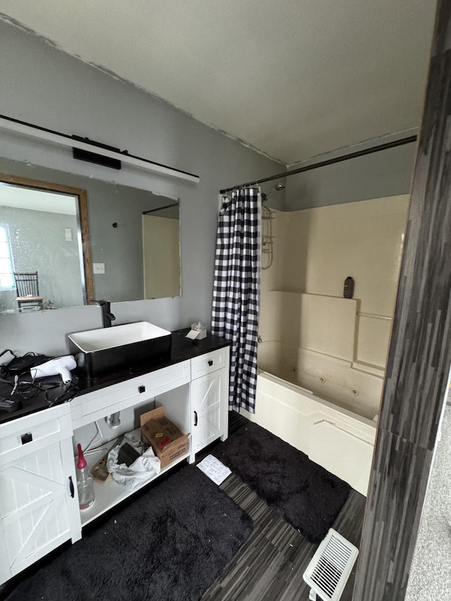 bathroom featuring visible vents, wood finished floors, shower / bath combination with curtain, and vanity