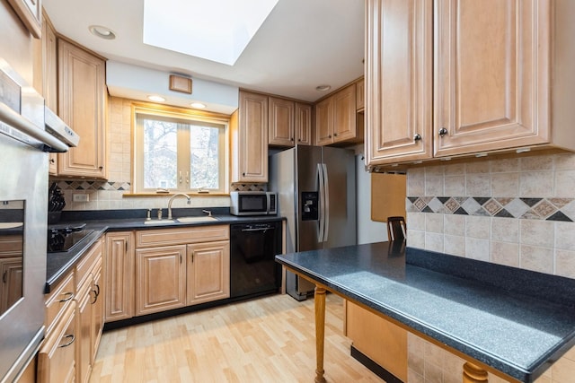 3528 Forest Ave, Wilmette, IL 60091 - kitchen featuring dark countertops, a sink, a skylight, black appliances, and tasteful backsplash