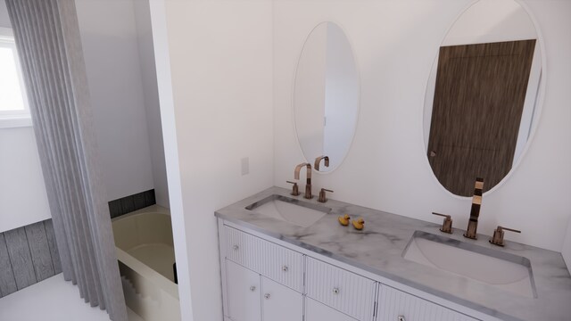 full bath featuring a sink, a tub, and double vanity
