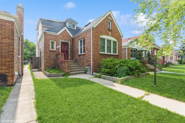 9940 S Normal Ave, Chicago, IL 60628 - view of front facade featuring brick siding, a front yard, and a shingled roof