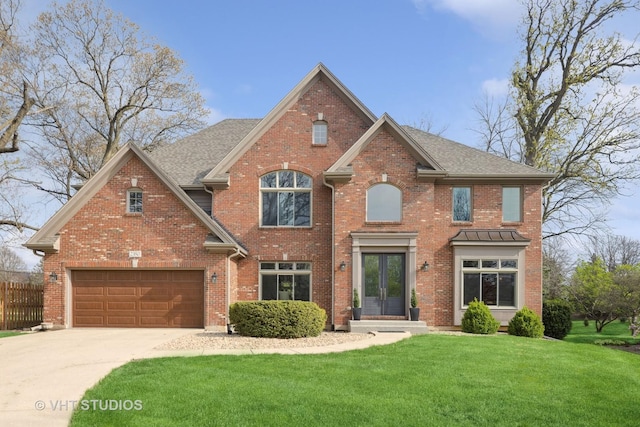 view of front of property with fence, a front lawn, brick siding, concrete driveway, and french doors