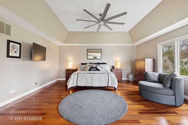 bedroom with visible vents, a raised ceiling, and wood finished floors