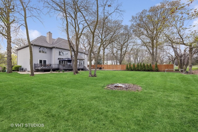 view of yard featuring fence, a wooden deck, and central AC unit