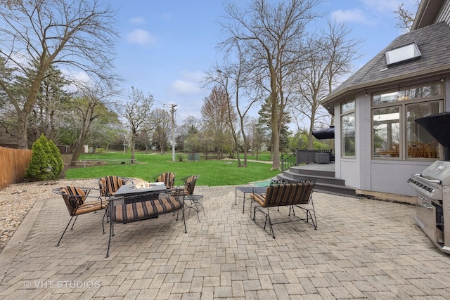 view of patio with an outdoor fire pit, fence, grilling area, and a deck