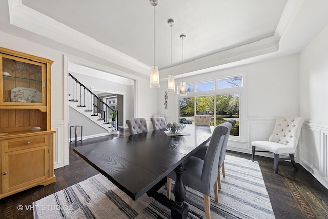 dining space featuring a tray ceiling, dark wood-style floors, and stairway