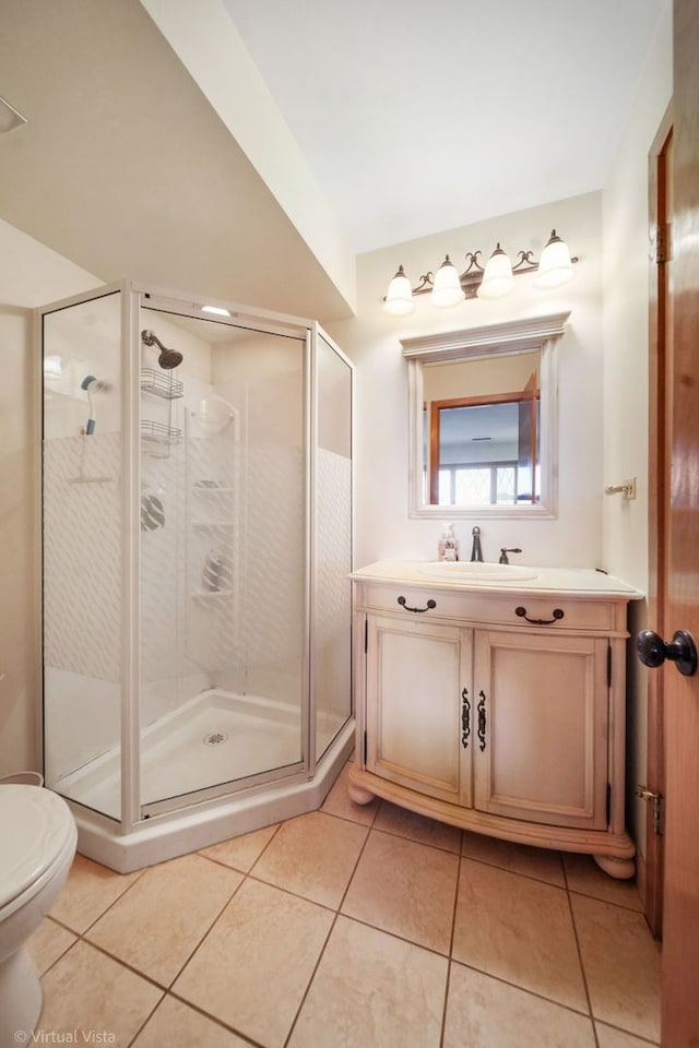 bathroom featuring a shower stall, tile patterned floors, vanity, and toilet