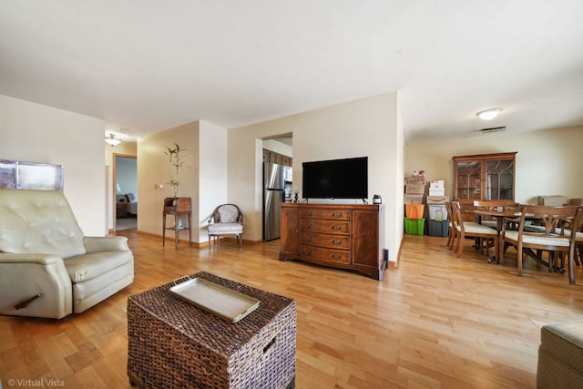 living area with light wood-type flooring and visible vents