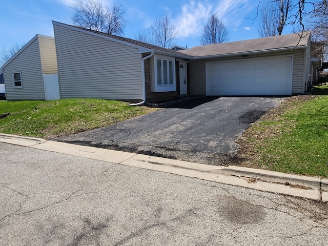 view of front of home with a garage, driveway, and a front lawn