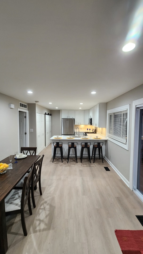 dining room featuring visible vents, baseboards, recessed lighting, and a barn door