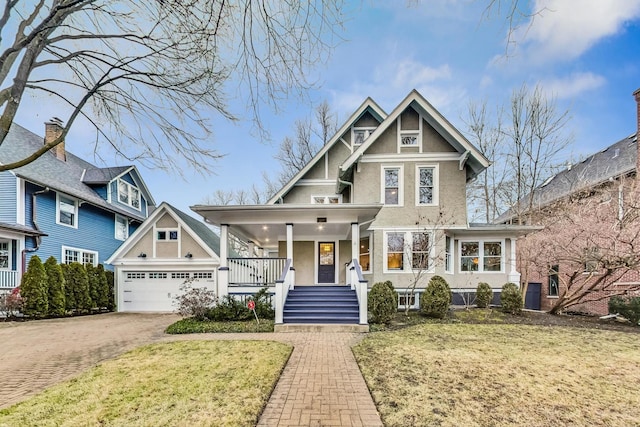 view of front of house featuring driveway, stucco siding, a front lawn, and covered porch