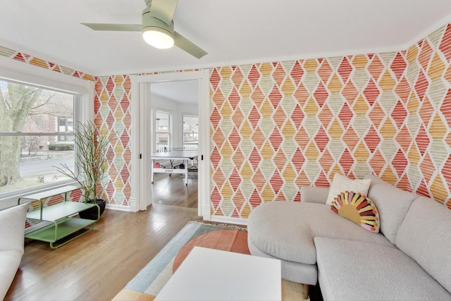 living area with wood finished floors, a ceiling fan, and plenty of natural light
