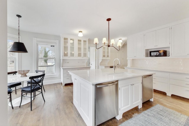 kitchen featuring a chandelier, dishwasher, a sink, and light countertops